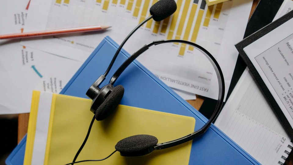 상담용 헤드셋과 응대 기록 자료가 놓인 책상